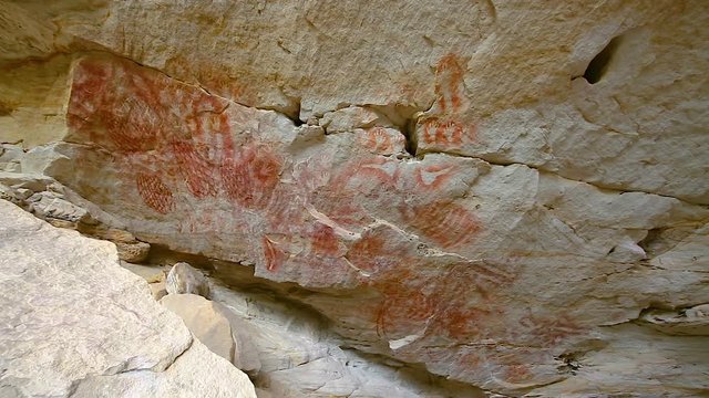 Left to right pan motion of cliff face know as Cathedral Cave at end of walking trail of Carnarvon Gorge. Walls have engravings, Ochre stencils, free-hand paintings which most are 1000's of years old 