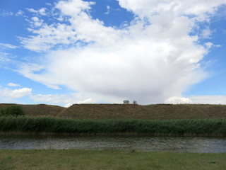 Blue sky with clouds over a river.