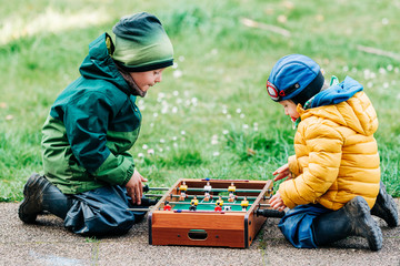Jungen spielen mit Kicker drau&szlig;en 3