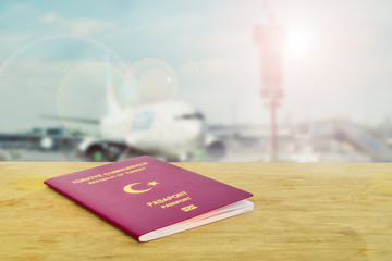 Public or tourist passport of Turkey on the table against to airport and flying plane. Travel concept photo for tourism company. Close up Turkish citizen ordinary passport.