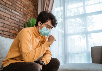 male on social distancing situation. virus symptoms. male wearing face masks coughing