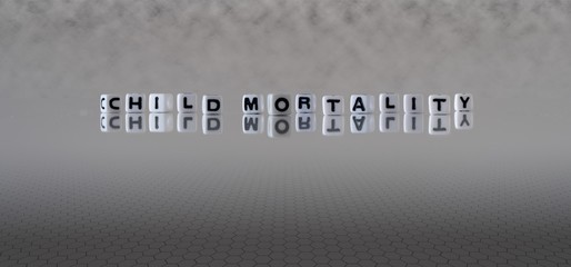 child mortality concept represented by black and white letter cubes on a grey horizon background stretching to infinity
