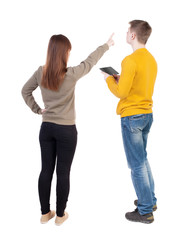 Back view of couple in sweater with mobile phone.