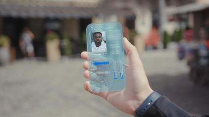 Income Call on his Transparent Phone. Future Smartphone. The Man Use Smartphone with Futuristic Design. Concept of Digital Future. Technology of Holographic. Digital Technology. Business Background.