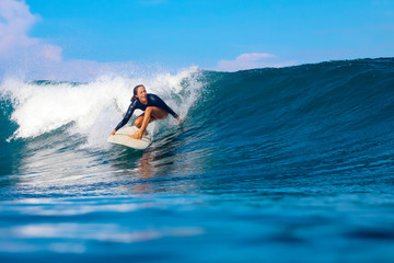 Female surfer on a blue wave