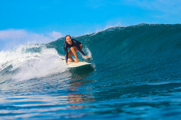 Female surfer on a blue wave - 331425001