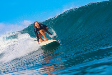 Female surfer on a blue wave