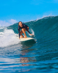 Female surfer on a blue wave - 331425076