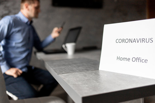 Pracownik w domu z kawą, napis home office, praca zdalna, coronavirus, covid-19