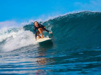 Female surfer on a blue wave