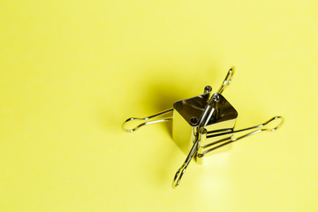 Metal binders on a yellow background. Stationery accessories. Paper clip