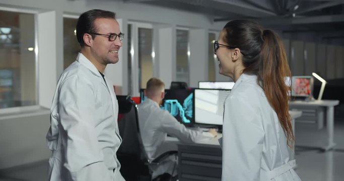 Cheerful technicians giving high-five in electronic lab