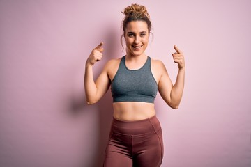 Young beautiful blonde sportswoman doing sport wearing sportswear over pink background smiling pointing to head with both hands finger, great idea or thought, good memory