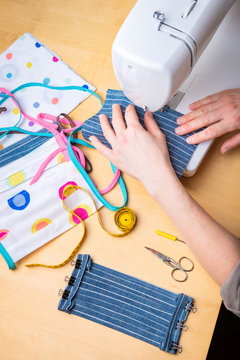 Woman Hands Using The Sewing Machine To Sew The Face Mask During The Coronavirus Pandemia. Domestic Sewing Due To The Shortage Of Medical Materials.