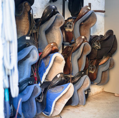 Different seats for horse riding at horse stable, nobody
