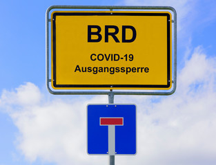Ausgangssperre wegen Coronavirus steht auf Ortsschild für BRD