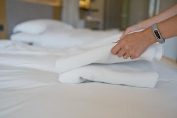 Obraz na płótnie Canvas cleaning hotel, bath towel on white bed, room service 