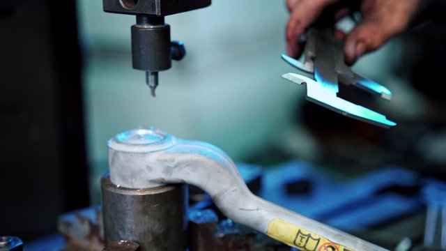Worker using vernier calipers. Industrial worker measuring detail with vernier caliper in factory workshop