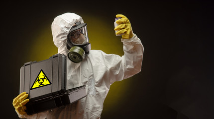 a man in a biological protective suit wearing a gas mask with medication for coronavirus