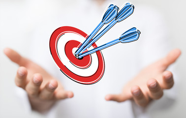 hand holding a target with darts hitting the center over white background. Concept of .