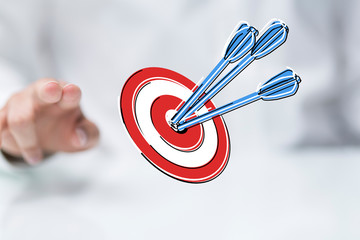 hand holding a target with darts hitting the center over white background. Concept of .