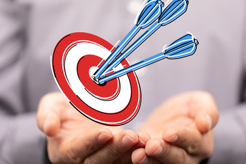 hand holding a target with darts hitting the center over white background. Concept of .