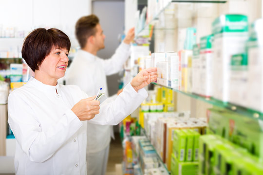 Pharmacist And Pharmacy Technician Posing In Drugstore