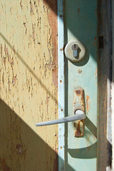 The handle of the old door with cracked paint.