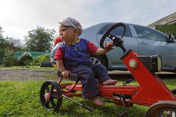 cheerful little child rides a toy car