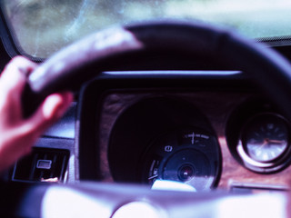 Close-up of a male hand on a steering wheel in an old car in Europe, steering wheel is on the left