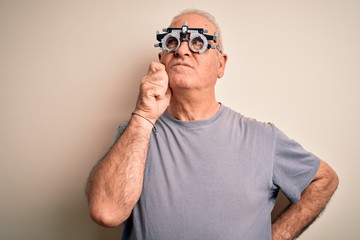 Fototapeta premium Middle age hoary man controlling vision wearing optometry glasses over white background with hand on chin thinking about question, pensive expression. Smiling with thoughtful face. Doubt concept.