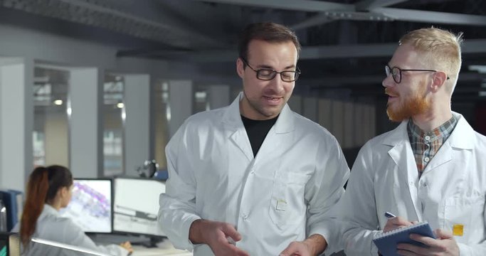 Scientists colleagues working together on computer in lab