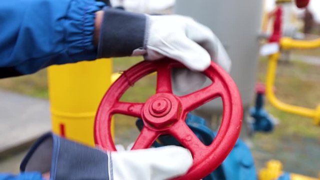 людина крутить кран у нафтогазовій галузі