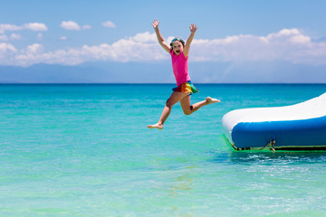 Kids on trampoline on tropical sea beach.