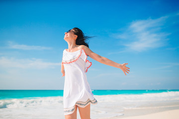 Fototapeta na wymiar Young woman enjoying the sun sunbathing by perfect turquoise ocean
