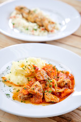 chicken with mashed potatoes and salad on the wooden background