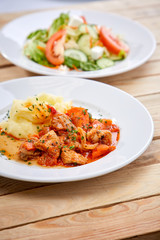 chicken with mashed potatoes and salad on the wooden background