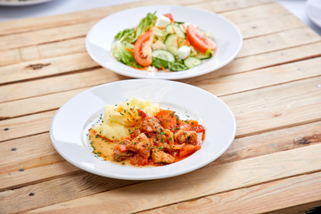 chicken with mashed potatoes and salad on the wooden background