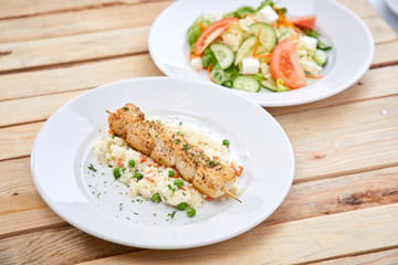 chicken kebab with rice and salad on the wooden background