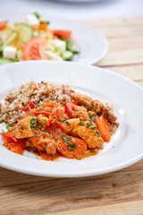 meat with buckwheat and salad on the wooden background