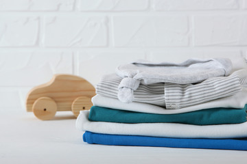 a stack of baby clothes on a light background.