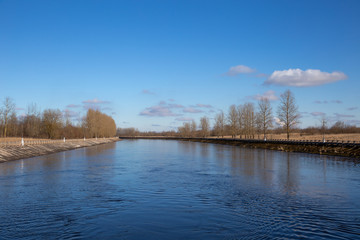 Water channel in the spring. Early spring has come. Trees without leaves, but the buds are already swelling