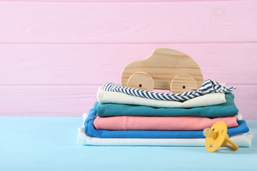 a stack of baby clothes on a light background.