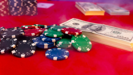 poker chips, dollars, cards on a red gaming table