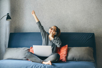 A girl works from home or a student is studying from home or a freelancer. She uses a laptop and a phone.