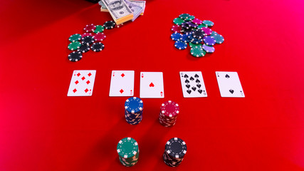 poker chips, dollars, cards on a red gaming table