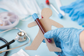 A doctor or nurse holds a test tube to send it to the lab for a blood test. hands of a laboratory assistant with a test tube for taking a blood sample for a virus or flu. Vaccine against the virus