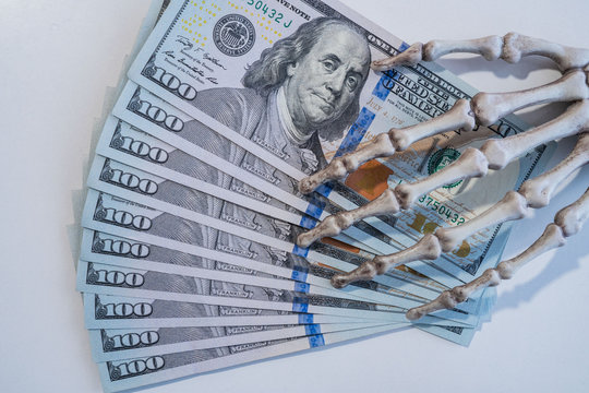 Pirate money. Skeleton hand holding dollars.