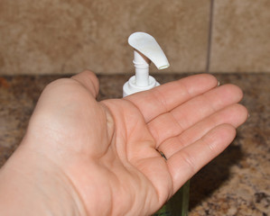 Close up image of an adult female protecting herself from covid 19 by using hand sanitizer 