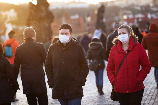 Couple Walking With Protected Faces By The Veils Threw Historical Centrum In Prague, Czech Republic, World During Pandemic Of Coronavirus.